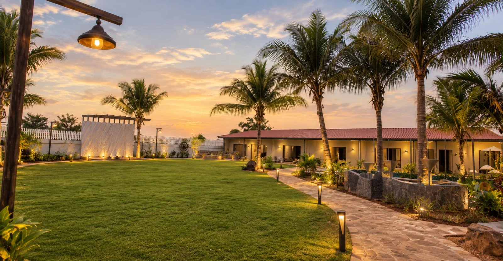 Sunset over the lawn, palms and villa veranda